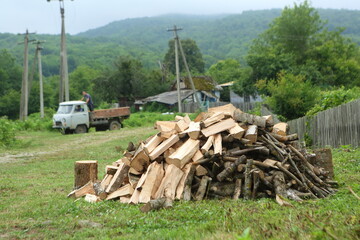A woodpile near a wooden fence