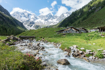 Berghütten am Wildbach mit Gletscher im Hintergrund - obrazy, fototapety, plakaty