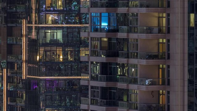 Windows of apartment buildings at night timelapse, the light from the windows of houses. Evening landscape of the city with glowing rooms