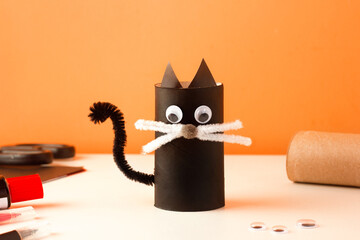 Creative craft for kids. Halloween family activity. Handmade decoration toilet paper roll cute black cat. Reuse concept