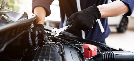 Fototapeta na wymiar Automobile mechanic repairman hands repairing a car engine automotive workshop with a wrench, car service and maintenance , Repair service