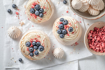 Traditional and delicious Pavlova dessert with fruits and white meringue.