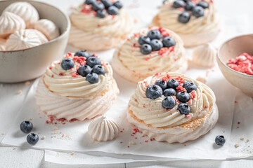 Creamy and sweet Pavlova dessert with fruits and white meringue.