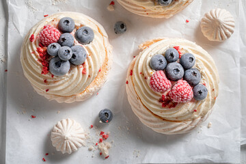 Traditional and delicious Pavlova dessert with whipped cream and fruit.
