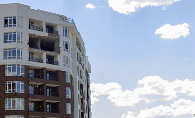 A residential building was damaged after being hit by a rocket. Holes from shells in a multi-storey building. Consequences of the war with Russia. Terrible destruction of the building by shells.