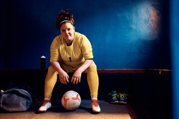 Female goalkeeper in dressing room looking at camera.