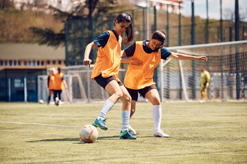 Female soccer players in action during practice on playing field.