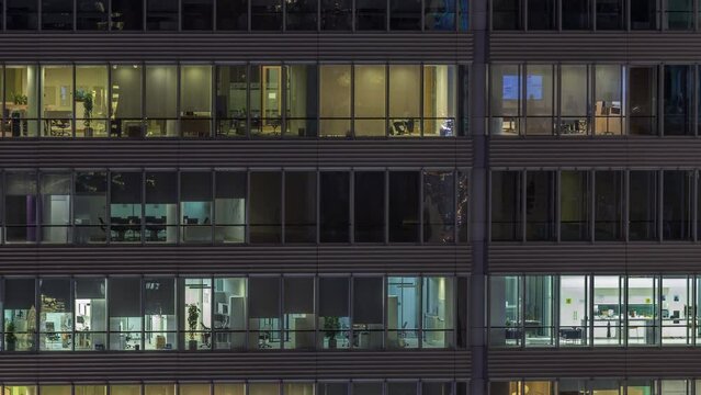 Windows of office buildings at night timelapse, the light from the windows of skyscrapers. Evening landscape of the city with glowing working place