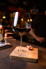 Glass of red wine on wooden table and dark background