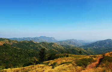 Fototapeta premium Mountain scape at Khao Kho National Park & Hot Springs in the morning at Phetchabun of Thailand in Winter, Sunny day and blue sky, Beautiful Natural View in Thailand, Natural wallpaper and background