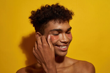 Black guy apply or correct under eye patch on face