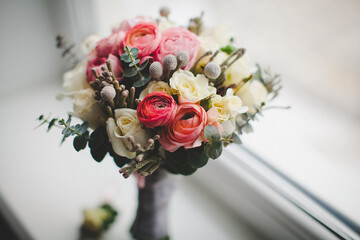 Colorful wedding bouquet on the windowsill in a vase