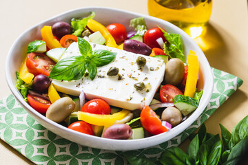 Classic Greek salad of fresh cucumber, tomato, sweet pepper, lettuce, red onion, feta cheese and olives with olive oil.