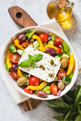 Classic Greek salad of fresh cucumber, tomato, sweet pepper, lettuce, red onion, feta cheese and olives with olive oil.