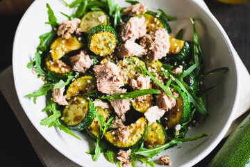 fresh salad with arugula, baked zucchini and tuna. the concept of healthy and nutritious food