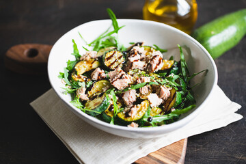 fresh salad with arugula, baked zucchini and tuna. the concept of healthy and nutritious food