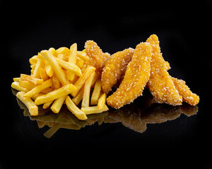 Chicken tenders, breaded nuggets and French fries, on a black background
