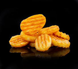 Pile of french fries over black background, round fried potatoes