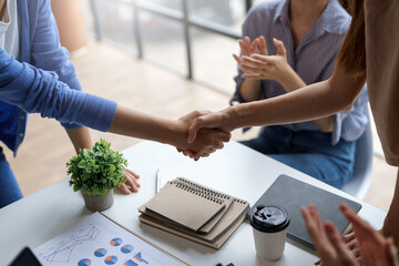 A group of Asian business people handshake to make a contract business agreement to start a new...