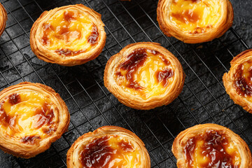 Traditional Portuguese custard tarts or Pastel de Nata freshly baked and cooling on rack