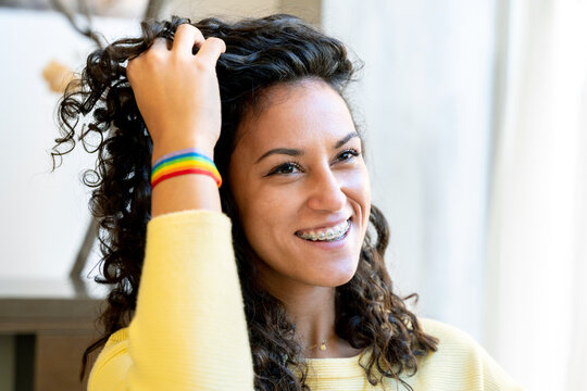 Happy woman with a rainbow lgbt bracelet in a salon