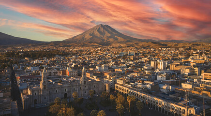 Aerial drone view of Arequipa main square and cathedral church, with the Misti volcano at sunset....