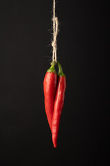 Chili pepper hanging on a rope on a black background