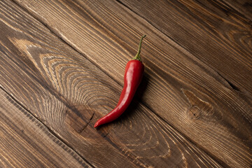 Chili pepper lies on an oak board