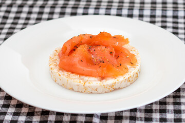 Tasty Rice Cake Sandwich with Fresh Salmon Slices on White Plate. Easy Breakfast and Diet Food. Crispbread with Red Fish. Healthy Dietary Snack