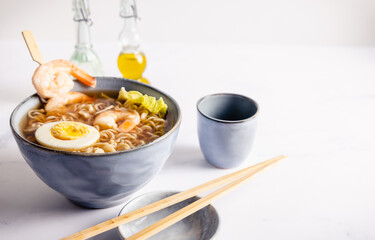Homemade Japanese ramen with noodles and shrimps in a bowl and chopsticks.