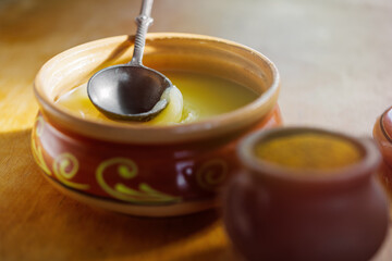 .Pure OR Desi Ghee also known as clarified liquid butter. Pure OR Desi Ghee in ceramic bowls on an...