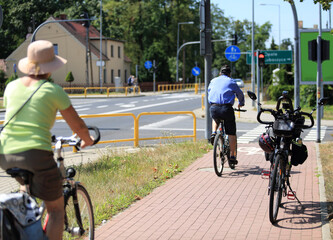 Rower i rowerzyści, mężczyzna i kobieta jadą ścieżką rowerową, skrzyżowanie. - obrazy, fototapety, plakaty