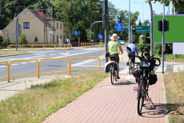 Rower i rowerzyści, mężczyzna i kobieta jadą ścieżką rowerową, skrzyżowanie.