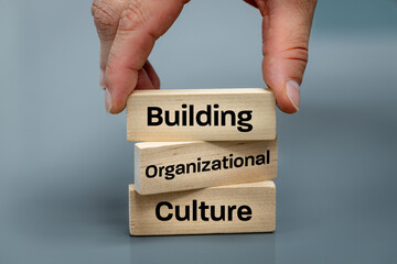 A wooden block with the words Building, Organizational, Culture, Modern approach to working with...