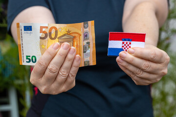 Croatian flag and 50 euro banknote, woman holding in hand, concept, Croatia Entry into the euro zone