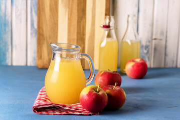 Homemade and Tasty Apple Juice with Pulp in the Glass Jug and Bottles Checkered Napkin Blue...