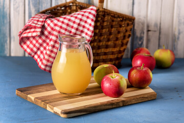 Healthy Organic Apple Juice in a Jug Red Napkin Red Apples Horizontal Rustic © katekrsk