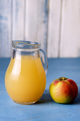 Jug of Apple Juice with Pulp on Blue Background Raw Red Appe Rustic Vertiacal