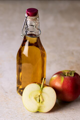 Glass Bottle with Apple Vinegar and Apple on Concrete Background Vertical Raw Red Apples