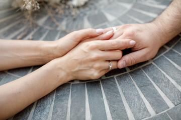 The bride and groom hold each other's hands