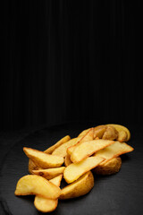 Fried potato wedges on black slate. Horizontal banner