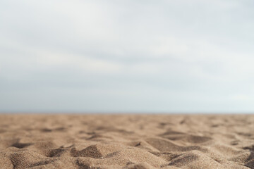 Closeup photo of sandy beach with sea and sky on background