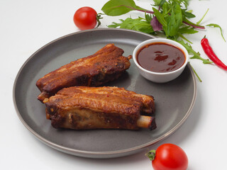 baked pork ribs with tomato sauce garnished with herbs and cherry tomatoes