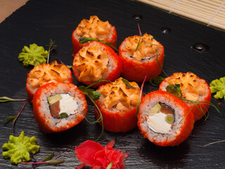 baked rolls with salmon, avocado, cream cheese in tobiko caviar