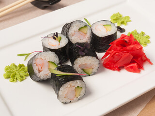 sushi rolls with shrimp and cucumber on a white plate