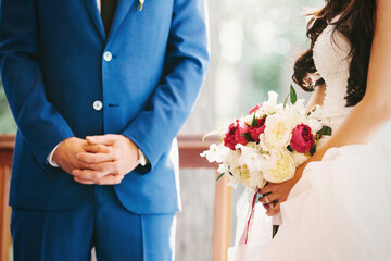 Obraz na płótnie Canvas Bride with bouquet and groom at the wedding ceremony