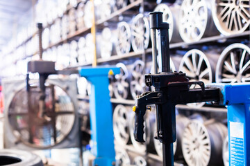 Fototapeta premium Selective focus to part of repair car wheel machine with blurry many alloy wheels.