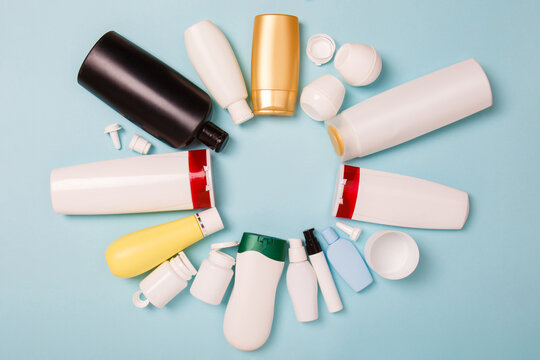 separate collection of sorted HDPE bottles from cosmetics for recycling in for of circle. High-Density Polyethylene recyclable cosmetics package on blue background. Plastic garbage. Save the planet