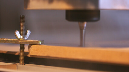 Close-up of wood cutting machine controlled by computer while he is carving wood. Action. CNC...