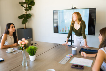 Beautiful boss talking with her female work team during a meeting